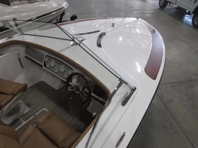 Slide: The Image of 2023 Thoroughbred u23i boat interior with brown leather seats and wooden dashboard. - 11
