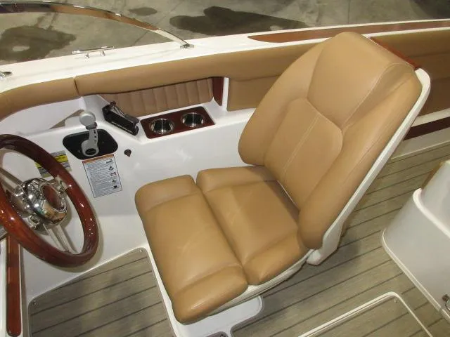 Slide: The Image of 2023 Thoroughbred u23i boat captain's seat with tan leather upholstery and wooden steering wheel. - 22