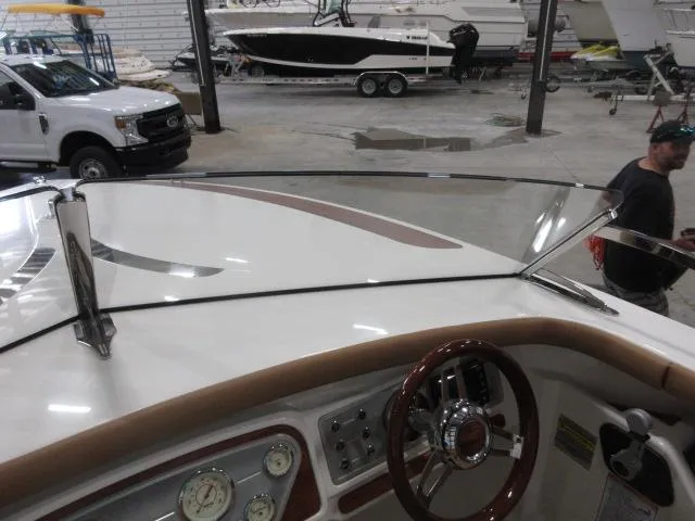 Slide: The Image of 2023 Thoroughbred u23i boat dashboard in a marina with other boats and vehicles. - 30
