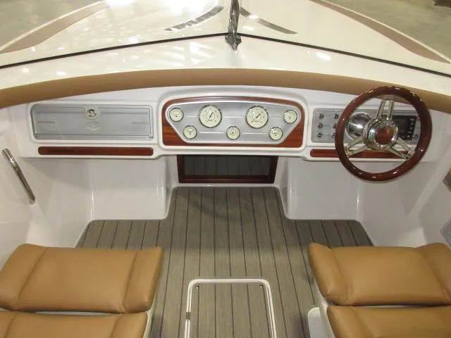 Slide: The Image of 2023 Thoroughbred u23i boat dashboard with classic gauges and wooden steering wheel. - 32