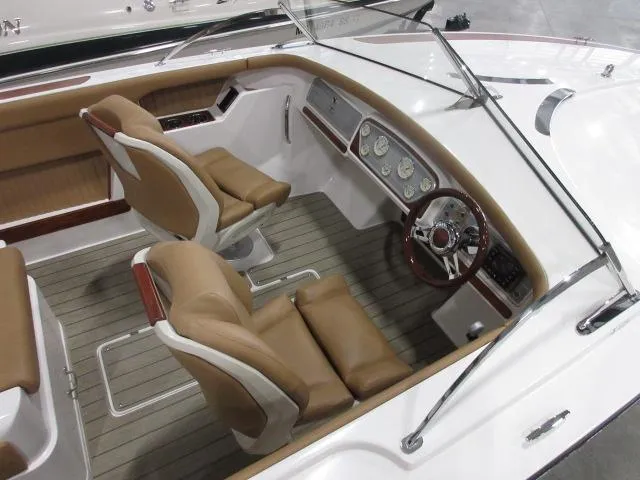 Slide: The Image of 2023 Thoroughbred u23i boat interior with tan seats and modern dashboard. - 9