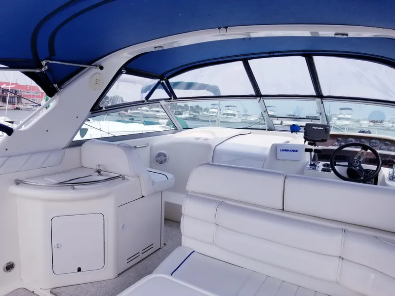 Slide: The Image of Interior of a 1996 Sea Ray 330 Sundancer boat with white seating and blue canopy. - 16