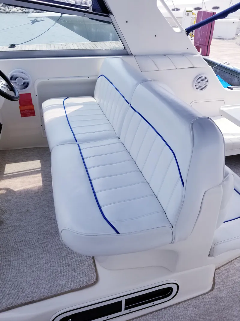 Slide: The Image of 1996 Sea Ray 330 Sundancer interior seating with white upholstery and blue trim. - 21
