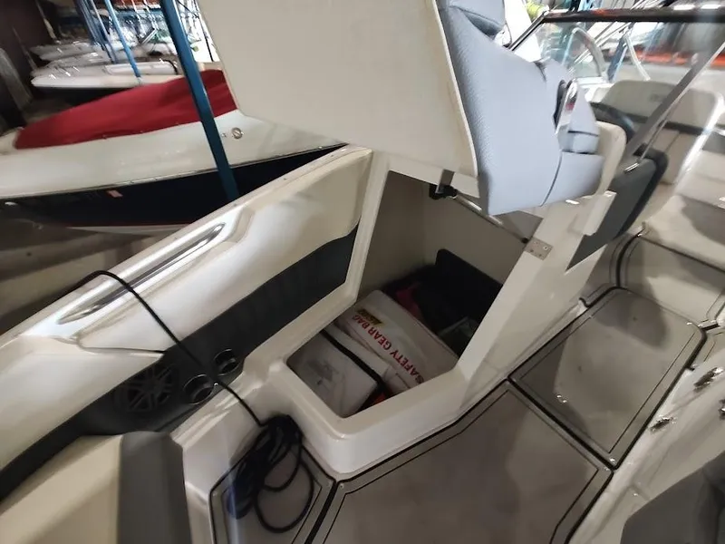 Slide: The Image of 2022 Cobalt 23SC boat interior with storage compartment and safety gear. - 20