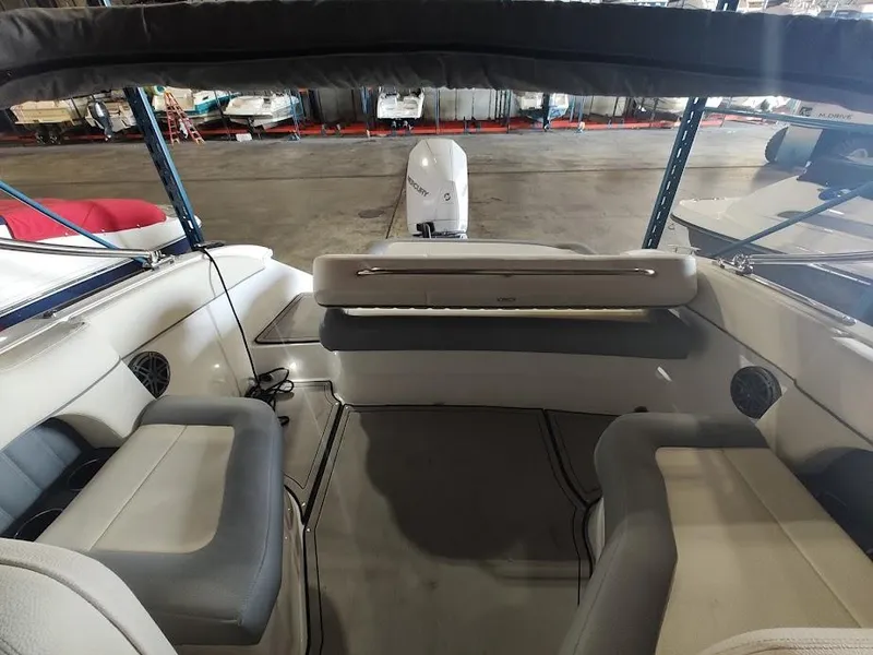 Slide: The Image of 2022 Cobalt 23SC boat interior with seating and outboard motor in a storage facility. - 26