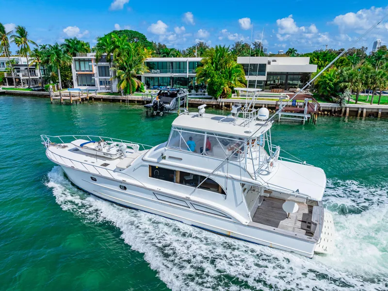 Slide: The Image of White 1996 Blackwell 72 yacht cruising near waterfront homes on a sunny day. - 24
