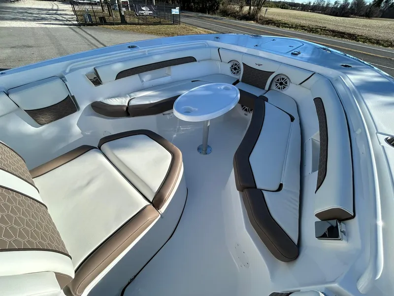 Slide: The Image of 2025 Tidewater 256 LXF boat interior with cushioned seating and round table. - 10