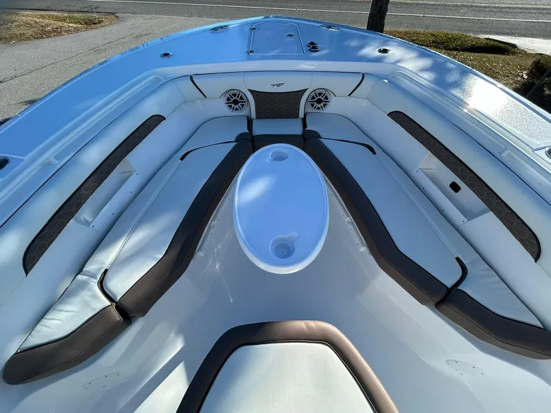 Slide: The Image of 2025 Tidewater 256 LXF boat interior with cushioned seating and speakers. - 11