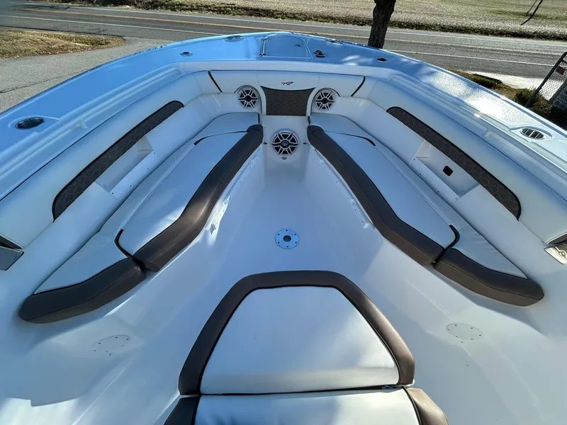 Slide: The Image of 2025 Tidewater 256 LXF boat interior with cushioned seating and speakers. - 15