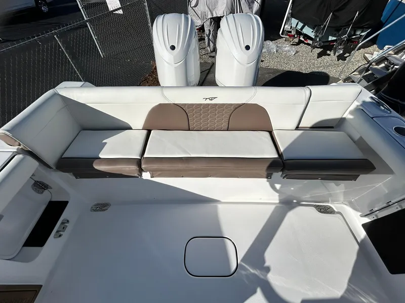 Slide: The Image of 2025 Tidewater 256 LXF boat interior with cushioned seating and dual engines. - 48