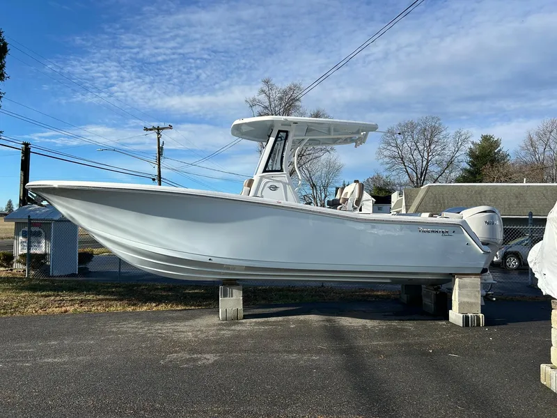 Slide: The Image of 2025 Tidewater 256 LXF boat on blocks, parked outdoors under a clear sky. - 92