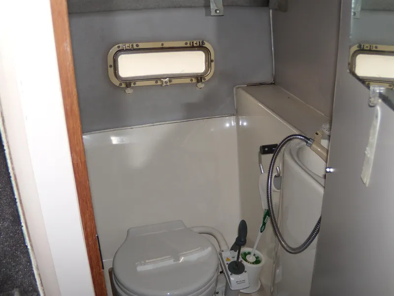 Slide: The Image of 1988 Bayliner 2655 Ciera Sunbridge boat bathroom with toilet and porthole window. - 13