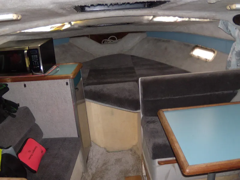 Slide: The Image of Interior of 1988 Bayliner 2655 Ciera Sunbridge with seating, table, and microwave. - 9