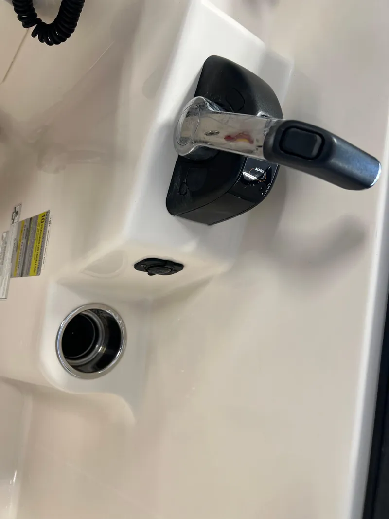 Slide: The Image of Close-up of the control lever on a 2016 Grady-White Freedom 225 boat. - 22