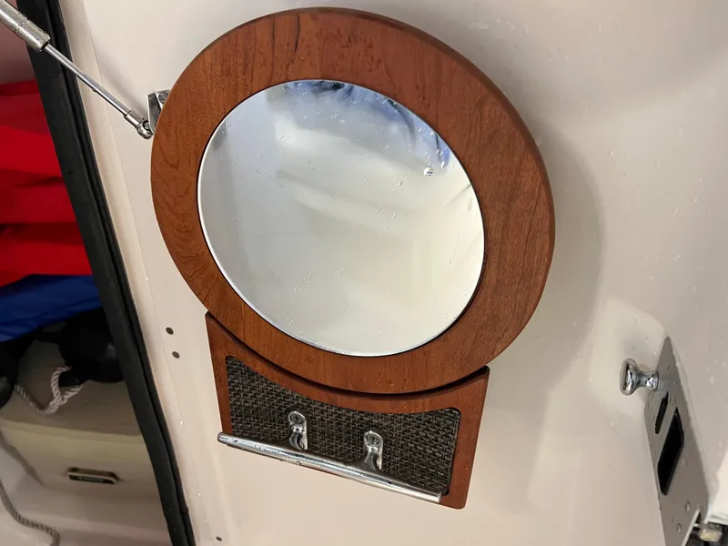 Slide: The Image of Round mirror with wooden frame on 2016 Grady-White Freedom 225 boat interior. - 31