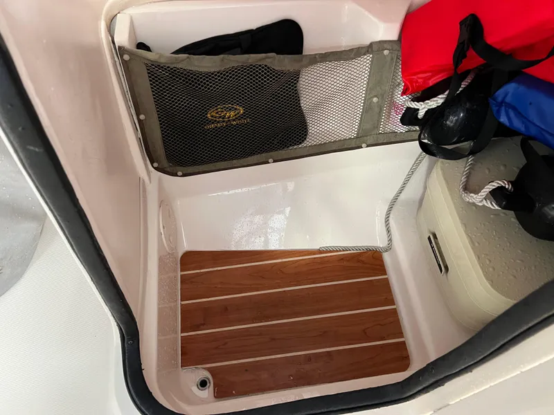Slide: The Image of Storage compartment in 2016 Grady-White Freedom 225 boat with wooden floor and mesh pocket. - 32
