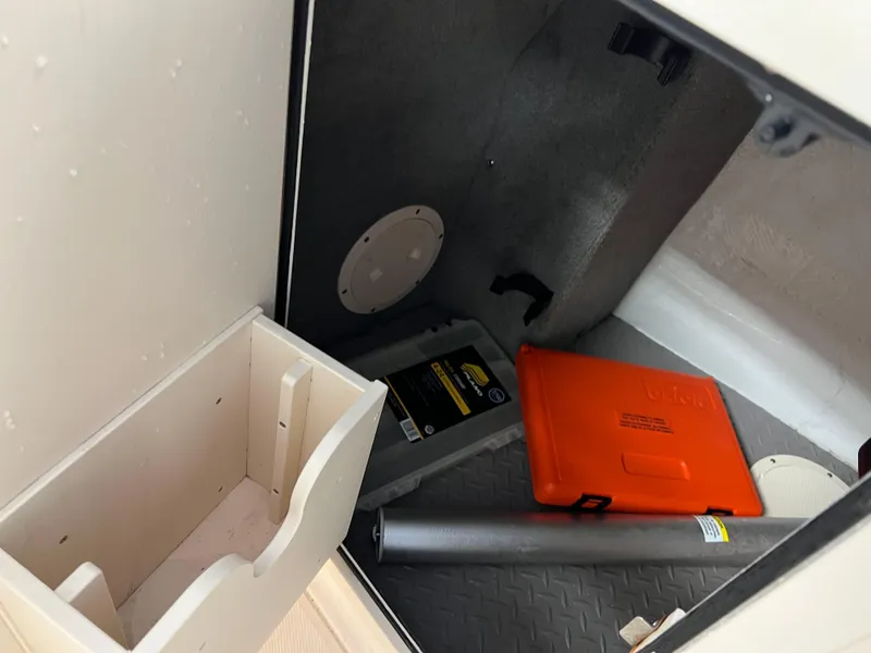 Slide: The Image of 2016 Grady-White Freedom 225 storage compartment with safety equipment and tools. - 4