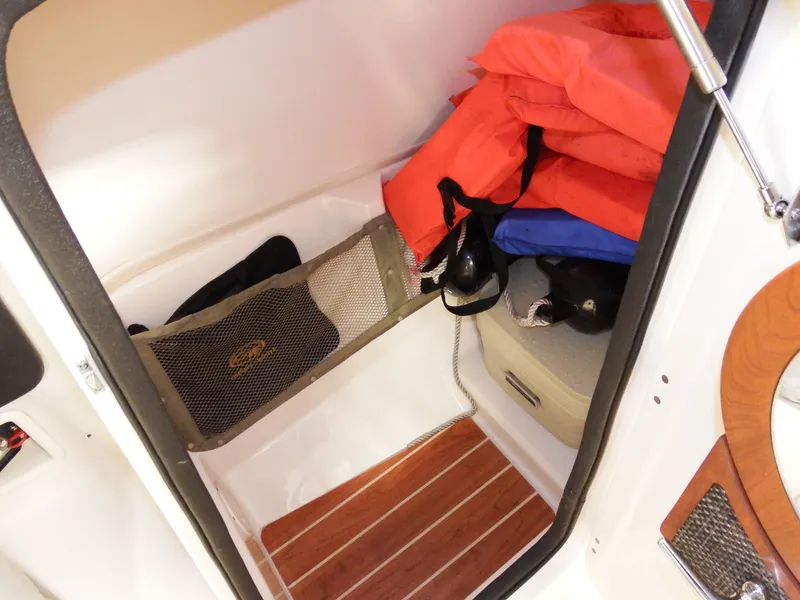 Slide: The Image of 2016 Grady-White Freedom 225 storage compartment with life jackets and accessories. - 49