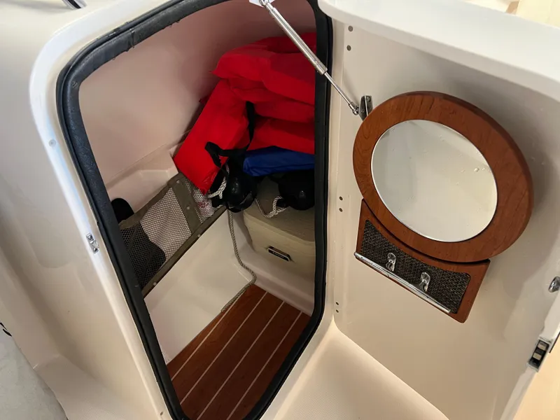 Slide: The Image of 2016 Grady-White Freedom 225 cabin interior with life jackets and mirror. - 5