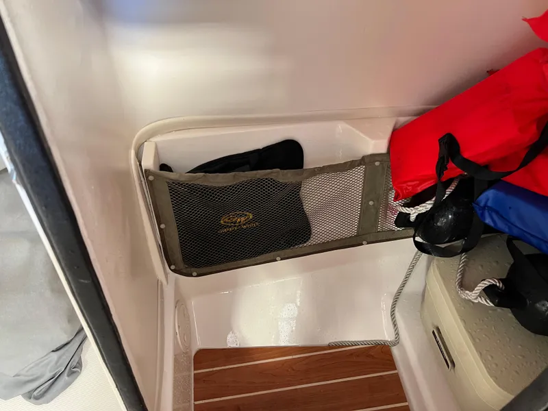 Slide: The Image of 2016 Grady-White Freedom 225 interior storage compartment with life jackets and netting. - 6