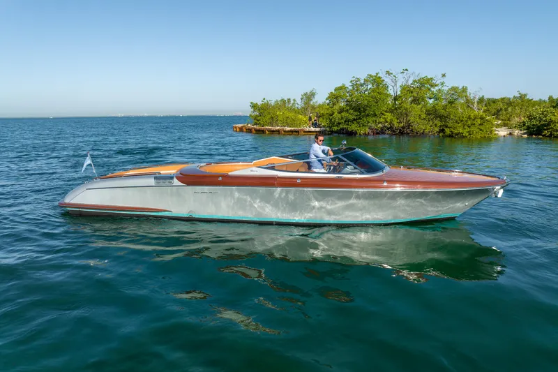 Slide: The Image of 2020 Riva Aquariva luxury speedboat cruising on clear blue water near a lush green island. - 3