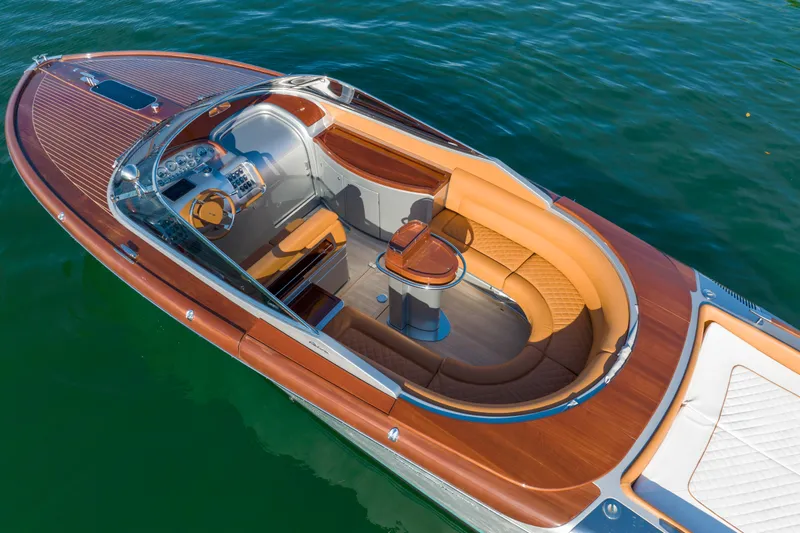 Slide: The Image of 2020 Riva Aquariva luxury boat with elegant wooden deck and plush seating on water. - 30