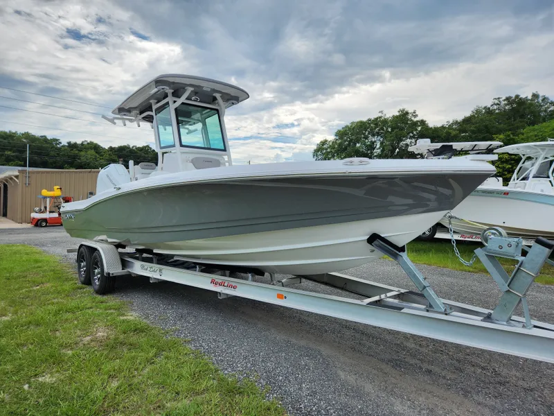 Slide: The Image of 2024 Caymas 28 HB boat on trailer, cloudy sky. - 11