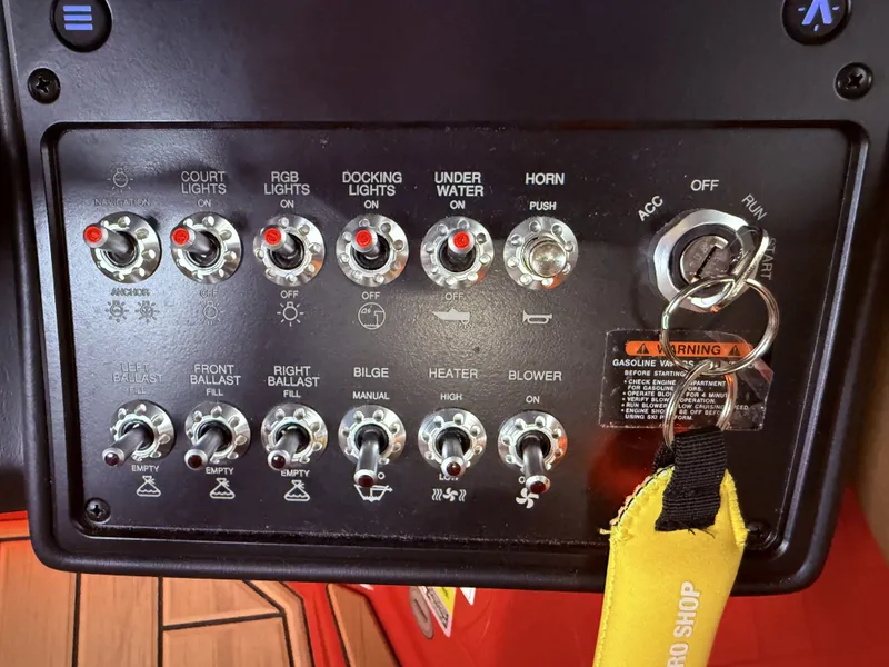 Slide: The Image of Dashboard of a 2023 Moomba Mojo boat with switches and ignition key. - 24