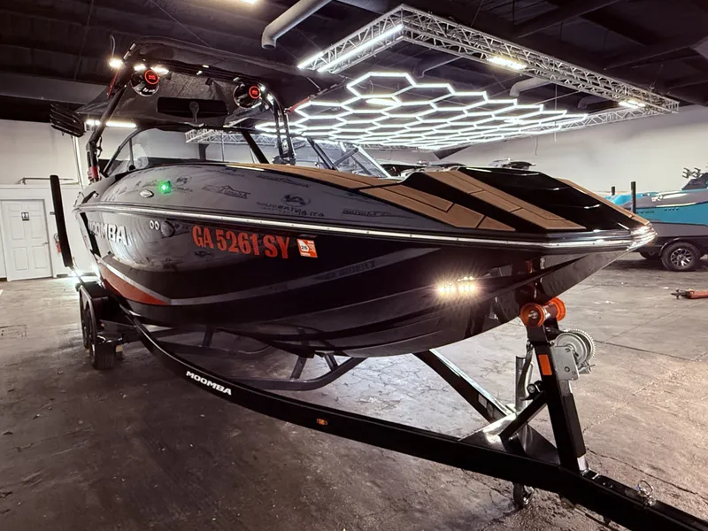 Slide: The Image of 2023 Moomba Mojo boat in a lit indoor space on a trailer. - 8