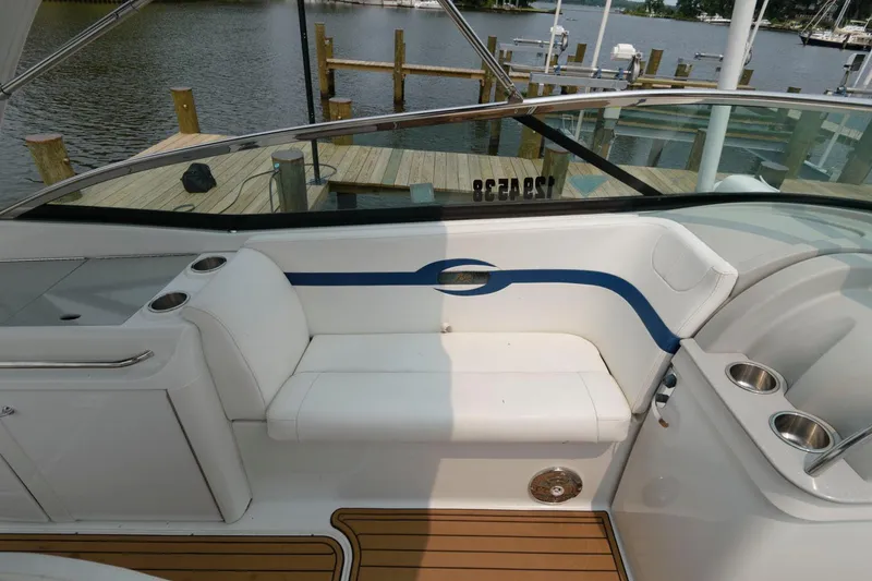 Slide: The Image of 2012 Formula 310 Bowrider interior seating area with cup holders and wooden deck. - 12