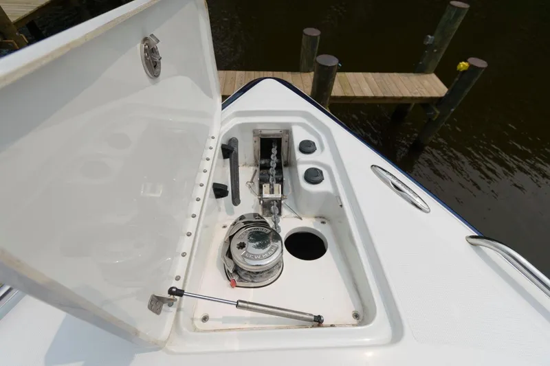 Slide: The Image of 2012 Formula 310 Bowrider anchor compartment with open hatch, dock in background. - 14