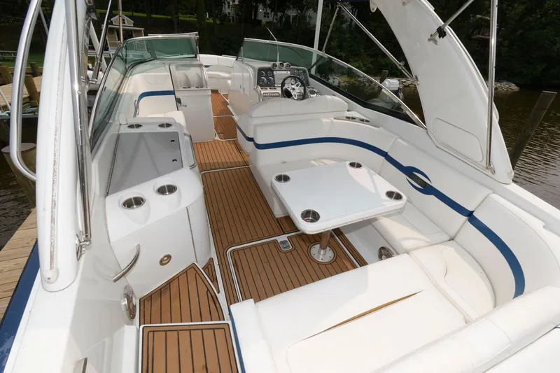 Slide: The Image of 2012 Formula 310 Bowrider boat interior with white seating and wooden flooring. - 4