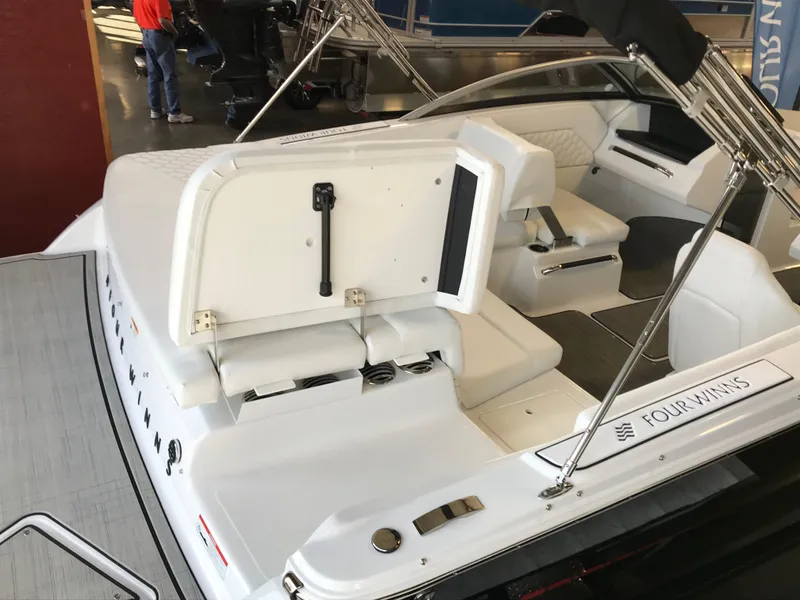 Slide: The Image of 2024 Four Winns H1 boat interior with white seating and open storage compartment. - 3