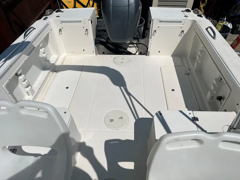 Slide: The Image of 2005 Aquasport 215 Explorer boat interior with seating and storage compartments. - 9