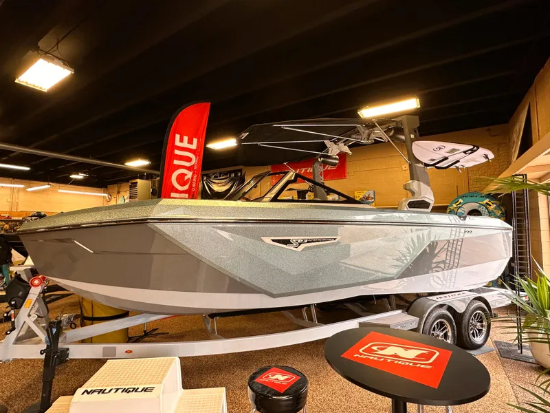 The Image of 2023 Nautique S23 boat on display in showroom with promotional materials. - 1