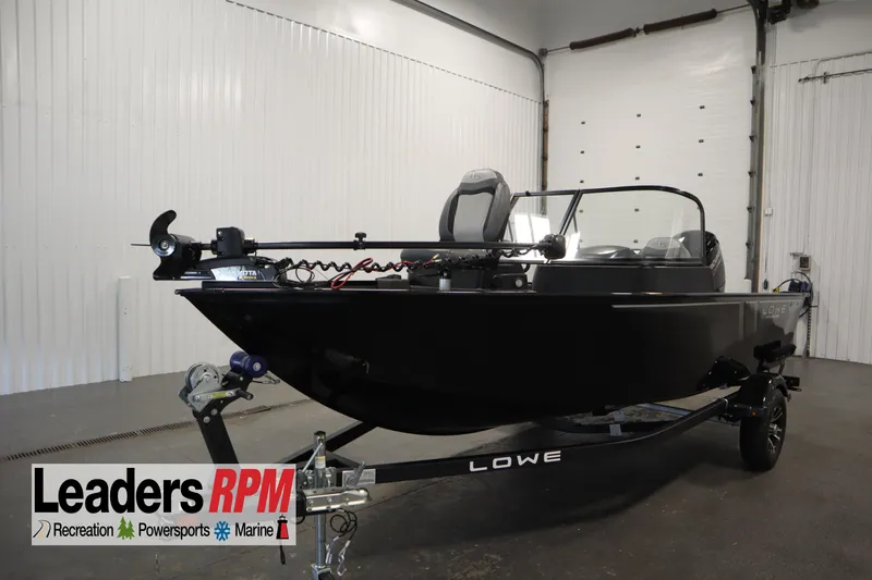 The Image of 2024 Lowe 1675 FM WT fishing boat in showroom, featuring sleek black design and modern equipment. - 1