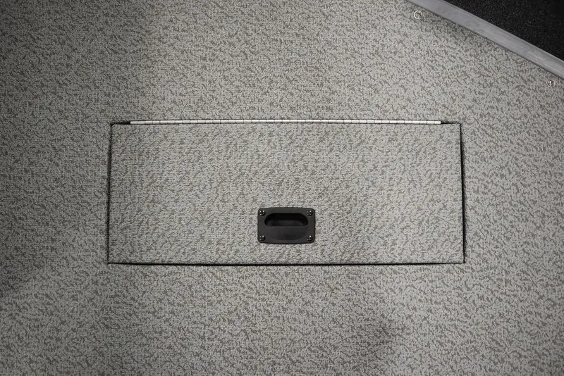 Slide: The Image of 2024 Lowe Fishing Machine 1675WT boat storage compartment with textured gray surface. - 18