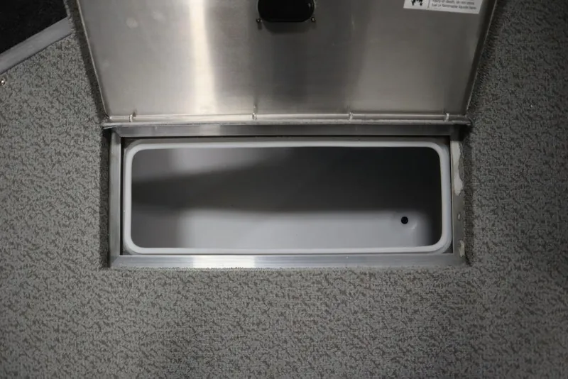 Slide: The Image of 2024 Lowe Fishing Machine 1675WT storage compartment, open with gray interior and carpeted surroundings. - 20