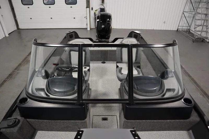 Slide: The Image of 2024 Lowe Fishing Machine 1675WT interior with dual seats and windshield in a showroom. - 21