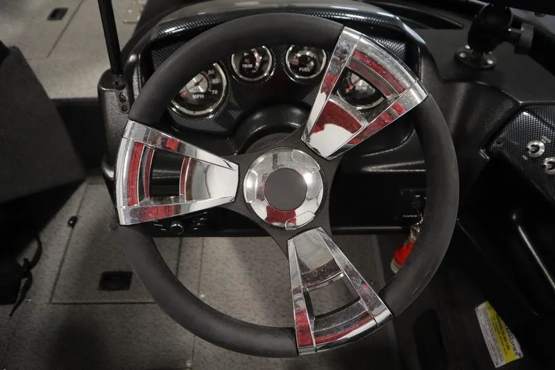 Slide: The Image of Steering wheel of 2024 Lowe Fishing Machine 1675WT with chrome accents and dashboard gauges. - 30
