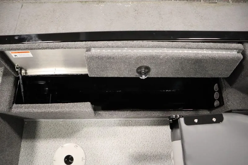 Slide: The Image of 2024 Lowe Fishing Machine 1675WT storage compartment, open and empty, with gray interior. - 38