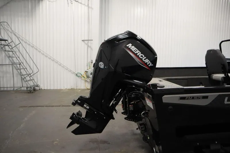 Slide: The Image of 2024 Lowe Fishing Machine 1675WT with Mercury outboard motor in a garage setting. - 47
