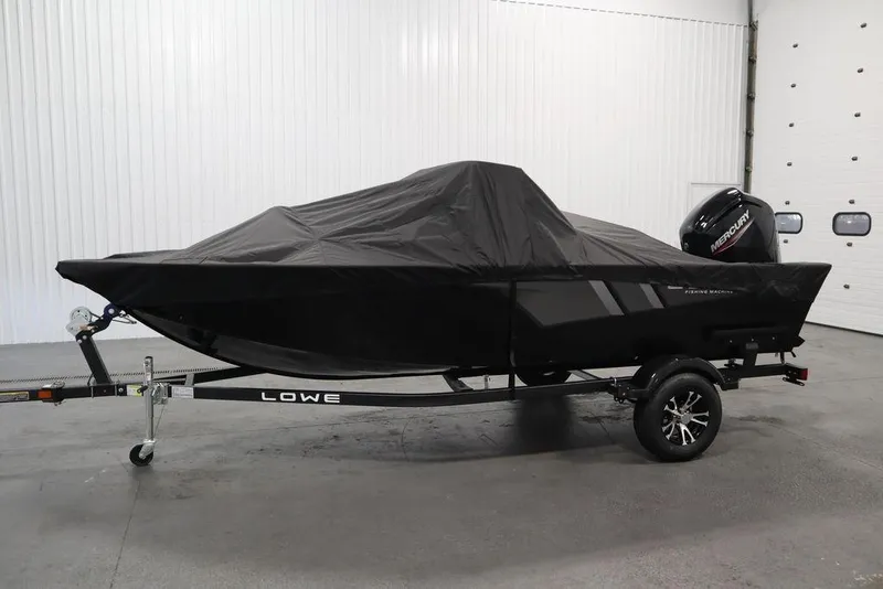 Slide: The Image of 2024 Lowe Fishing Machine 1675WT boat with cover on trailer in garage. - 51