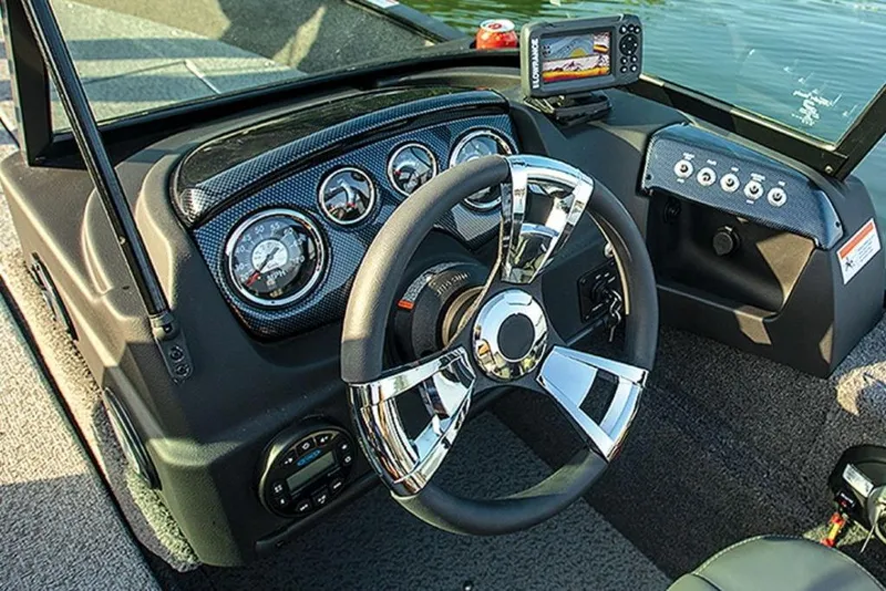 Slide: The Image of 2024 Lowe Fishing Machine 1675WT dashboard with chrome steering wheel and modern controls. - 52