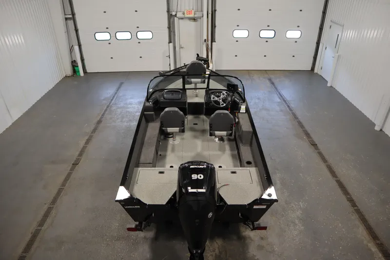 Slide: The Image of 2024 Lowe Fishing Machine 1675WT boat with Mercury engine in a garage setting. - 6