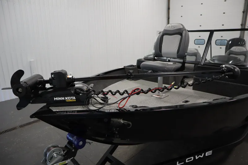 Slide: The Image of 2024 Lowe Fishing Machine 1675WT with Mercury outboard motor in a garage setting. - 7