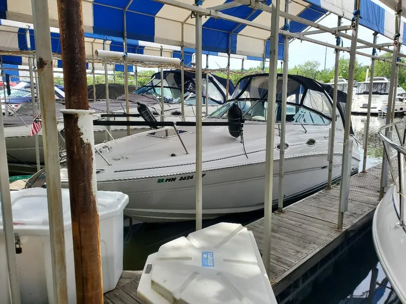 Slide: The Image of 2006 Sea Ray 280 Sundancer docked under a blue and white canopy. - 1