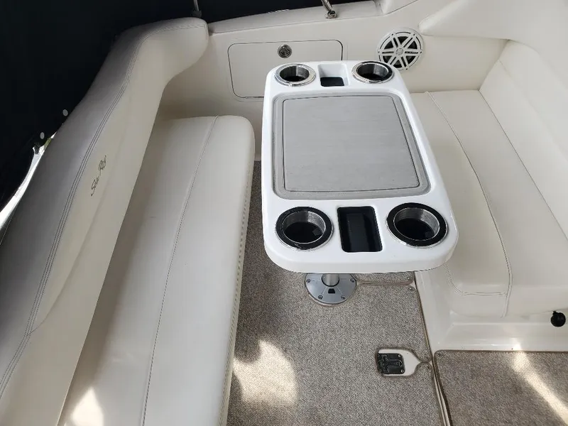 Slide: The Image of Interior seating area of a 2006 Sea Ray 280 Sundancer with a table and cup holders. - 14