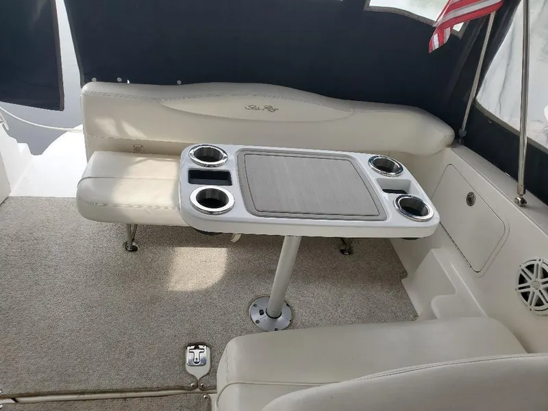 Slide: The Image of 2006 Sea Ray 280 Sundancer interior with seating and table, featuring cup holders. - 2