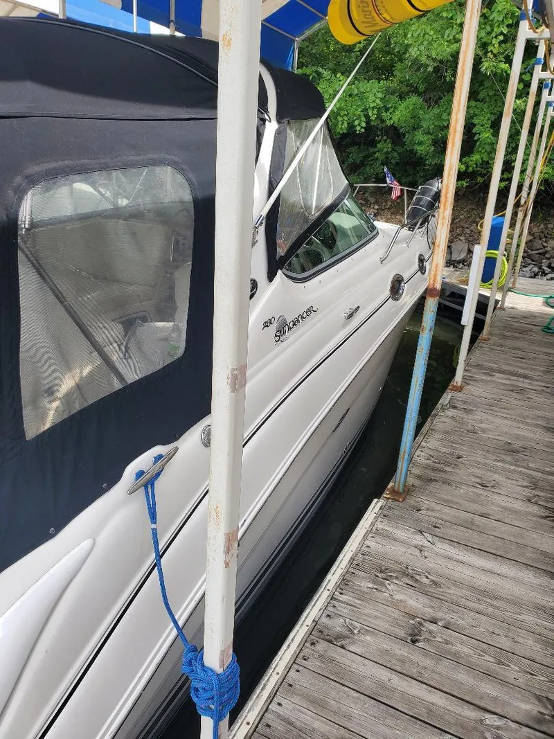 Slide: The Image of 2006 Sea Ray 280 Sundancer docked, featuring sleek design and black canopy. - 8